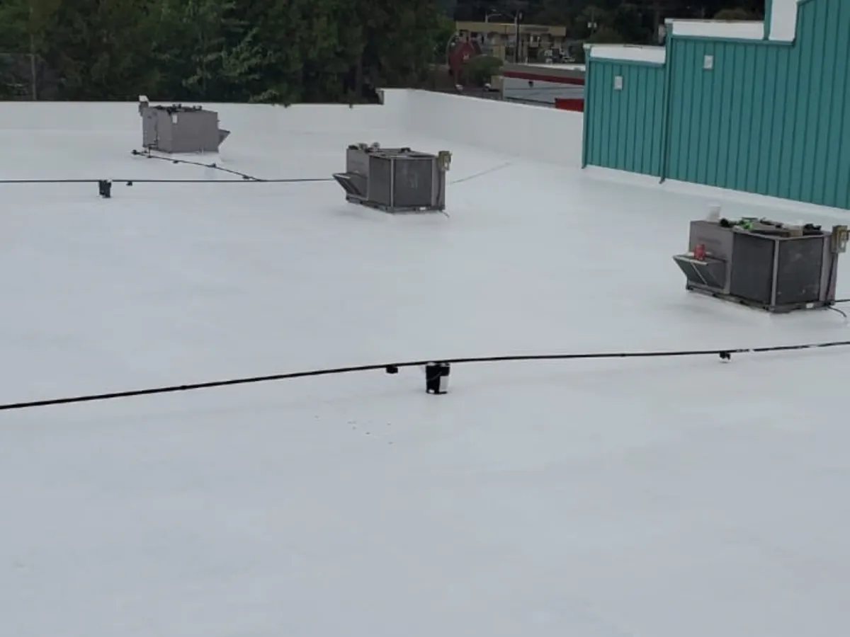 Flat roof with white TPO membrane around rooftop HVAC units