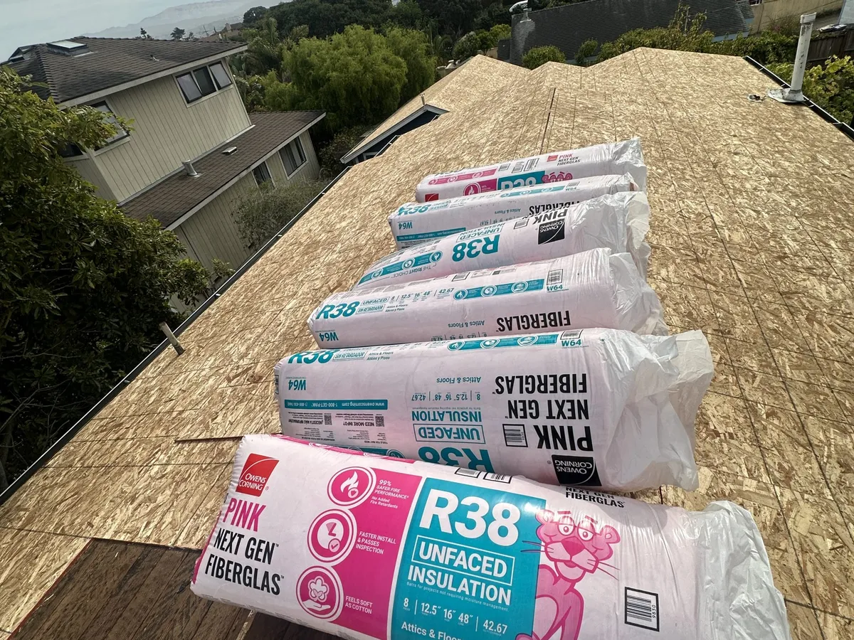 R-38 insulation staged on a roof deck for a retrofit