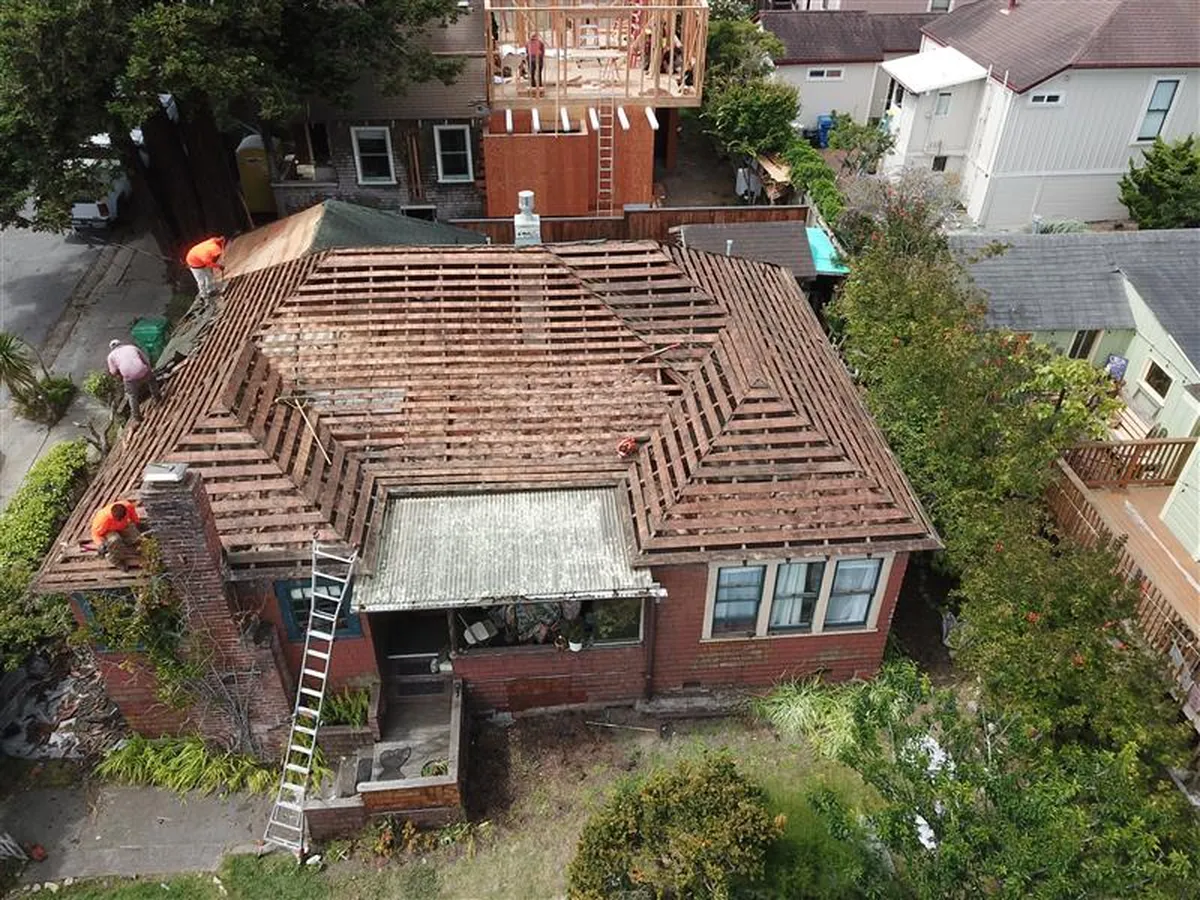 Aerial view of a full roof tear-off down to the rafters before a roof replacement
