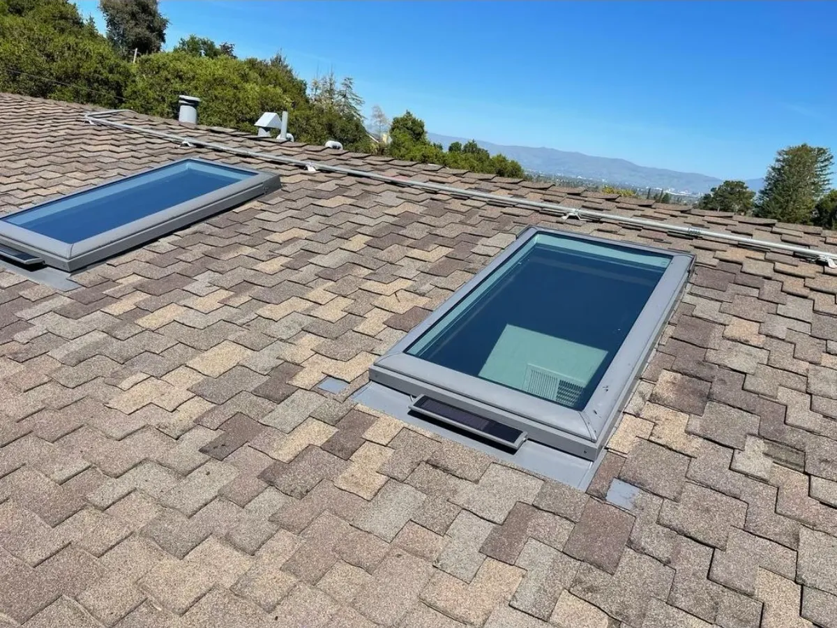 New skylights on a shingle roof with Bay Area hills behind